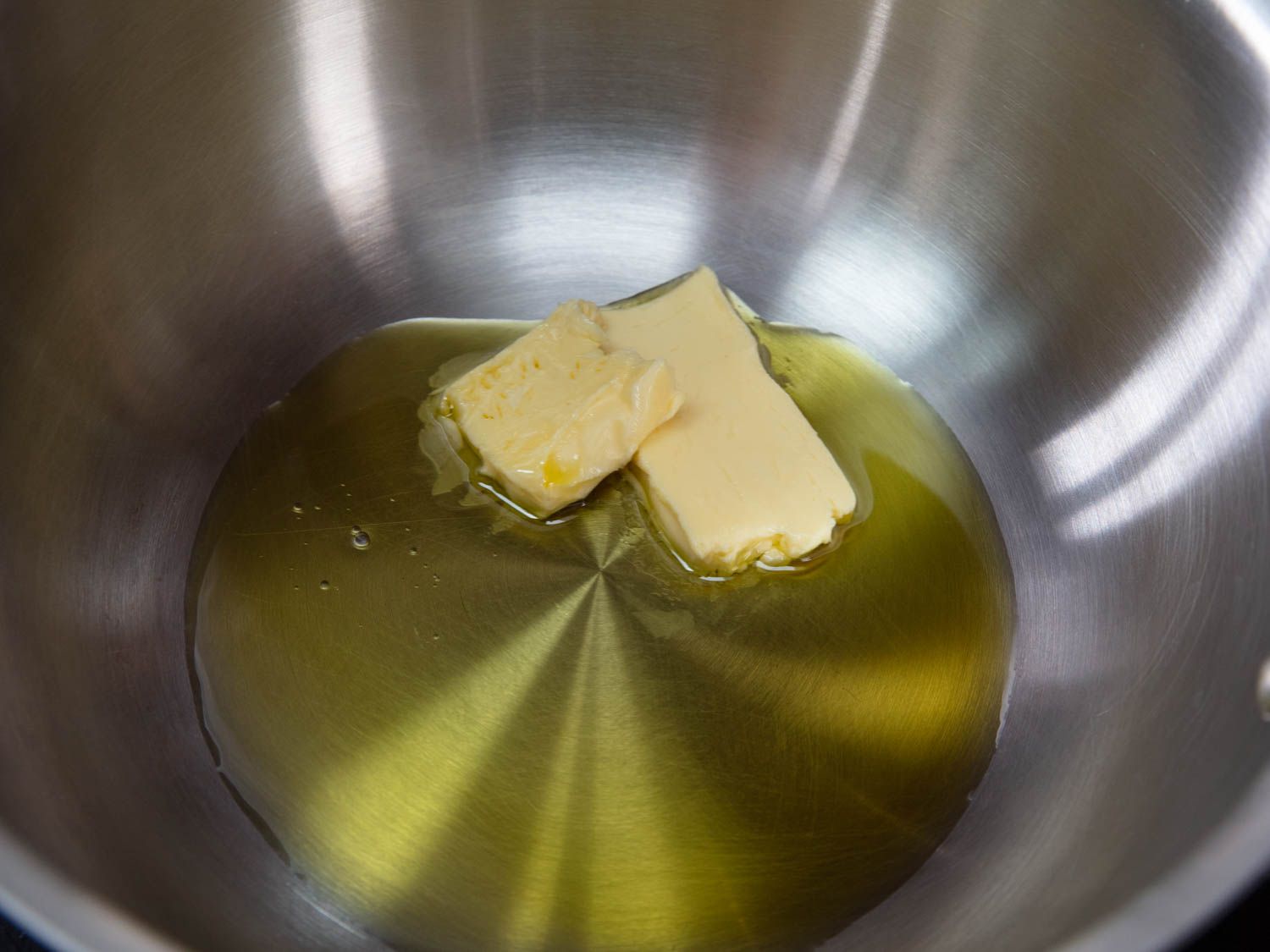 Butter and oil in a pan prepped to toast arborio rice for risotto