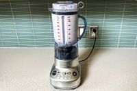 The Breville Fresh and Furious Blender plugged into an outlet on a kitchen counter