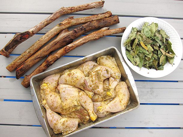 Overhead shot of pimento wood, bay leaves, and marinated chicken
