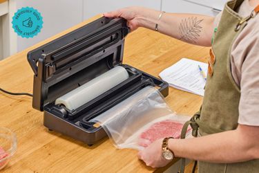  A person using an Anova vacuum sealer