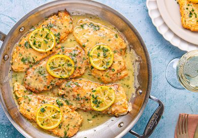 Chicken Francese served in a pan with lemon slices and sauce