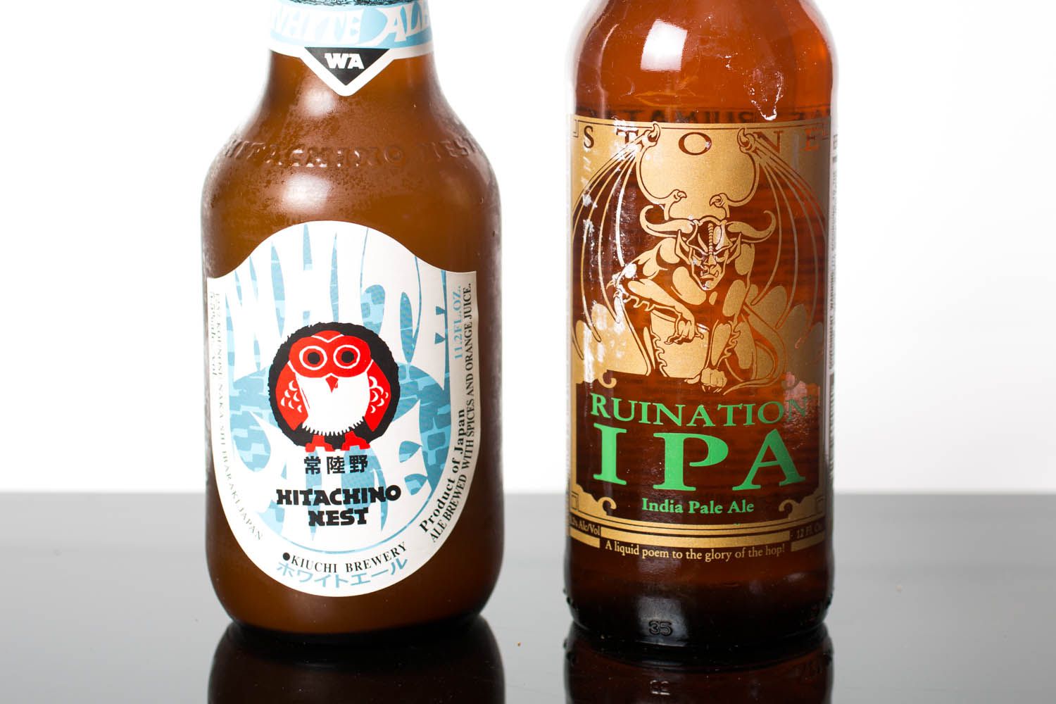 Closeup of the two ingredients needed for a white IPA: a bottle of IPA and a bottle of witbier.