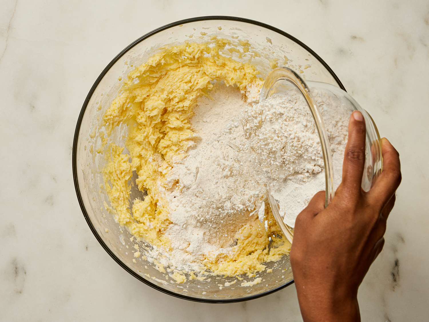 Adding dry ingredients to butter mixture bowl 