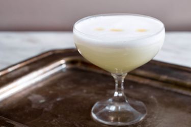 Pisco sour in a cocktail glass on a tray