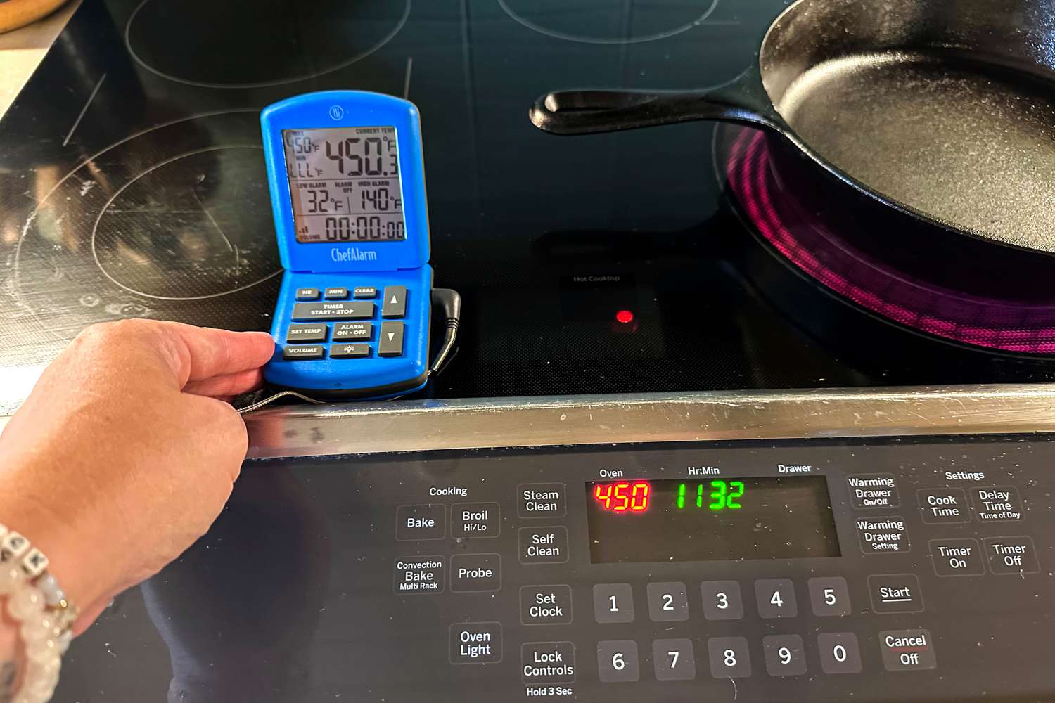 A digital oven thermometer sitting on a stovetop, accurately showing the temperature.