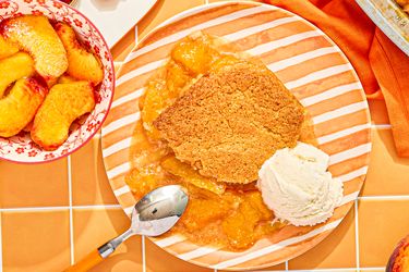 Peach cobbler with ice cream on a striped plate
