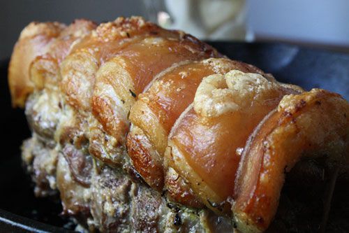 A slab of pork brisket rolled and secured with butcher's twine. 