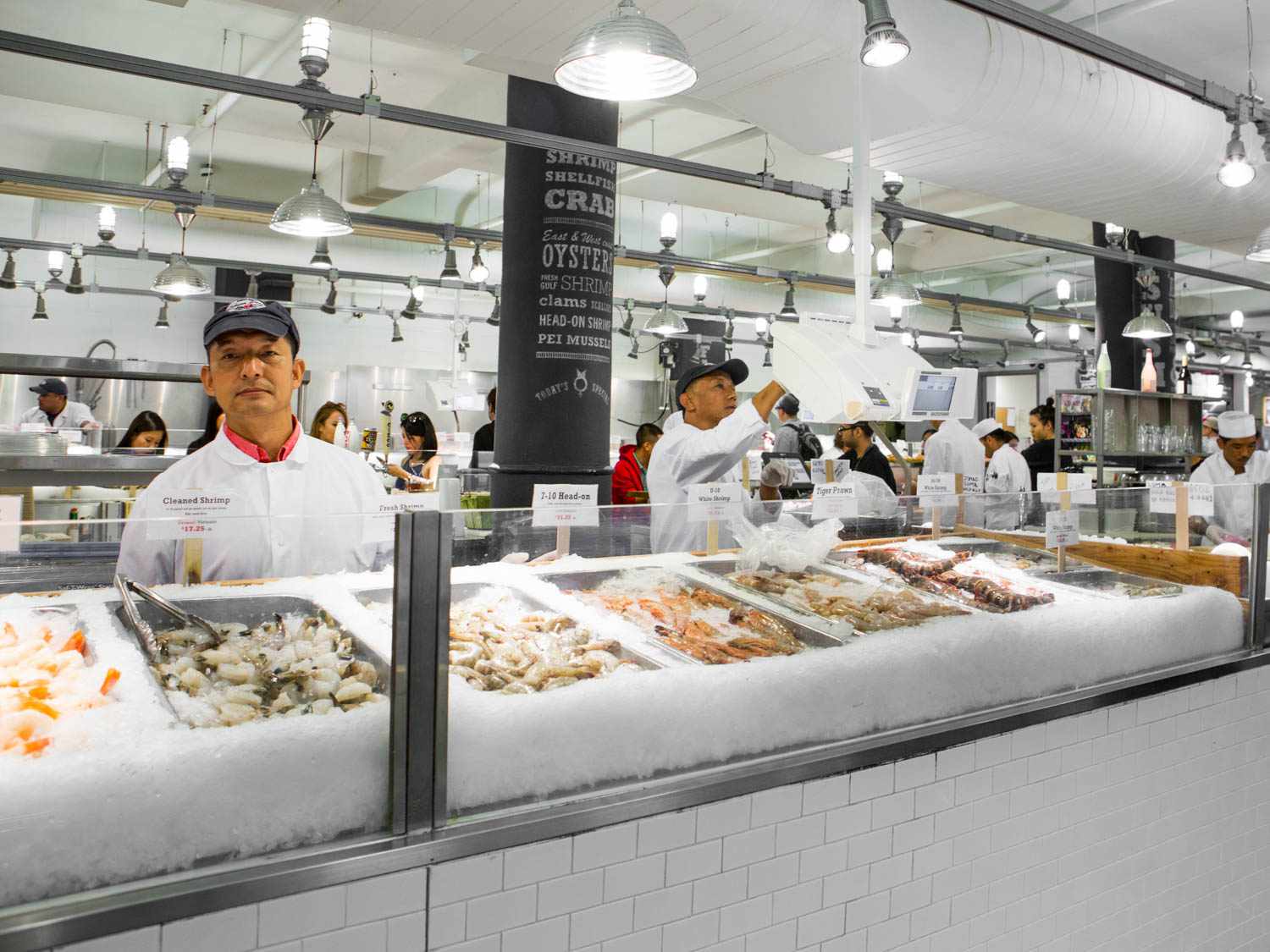 attendant behind retail raw shrimp counter