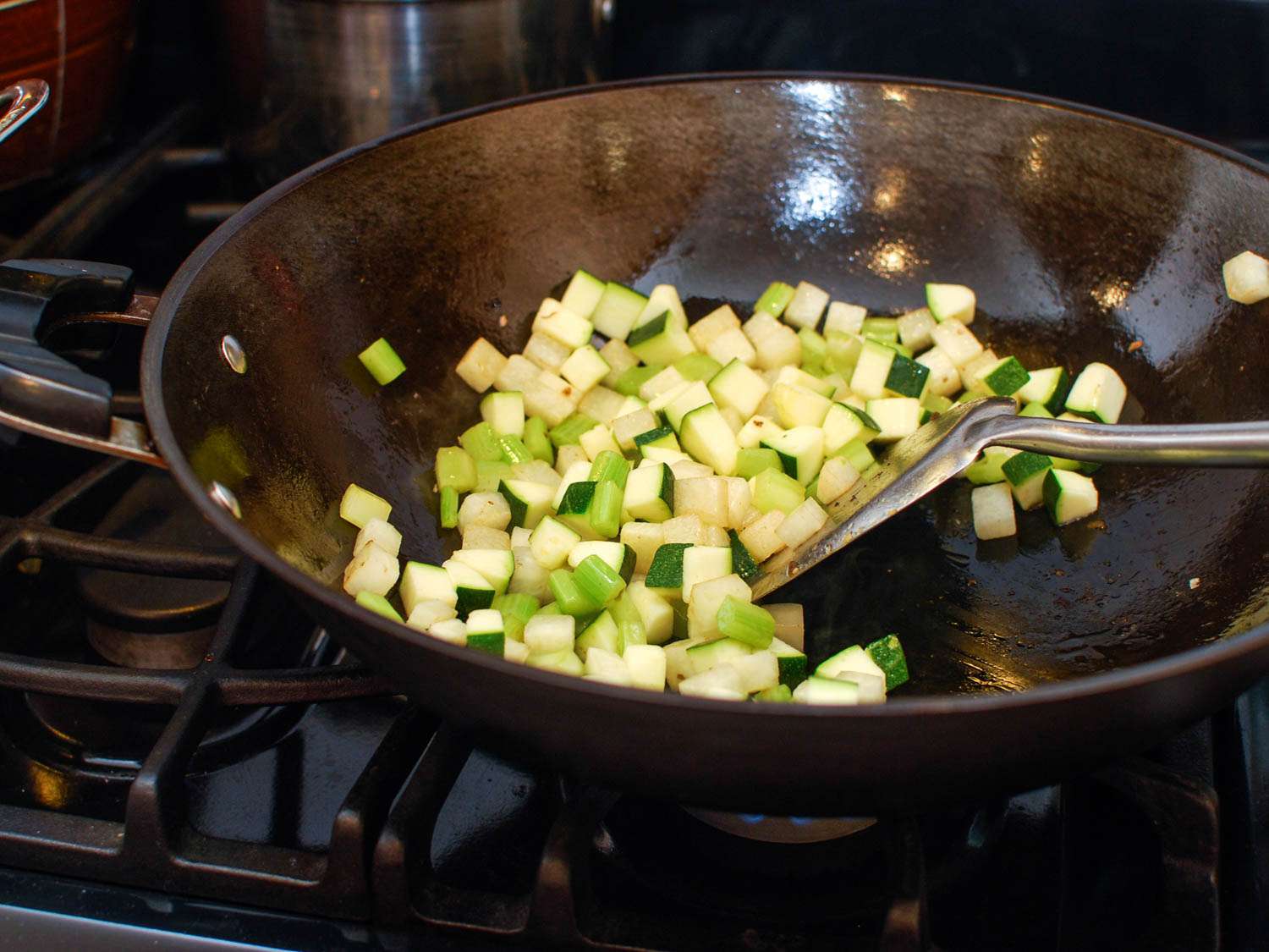 Stir-frying vegetables in a wok for cashew chicken ding.