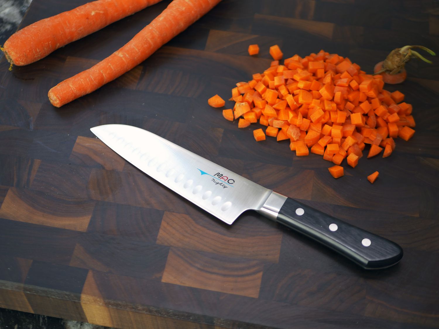 mac hollow edge santoku on a cutting board with carrots