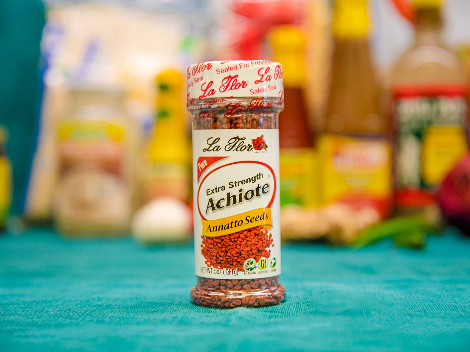 A bottle of Achiote on a blue backdrop