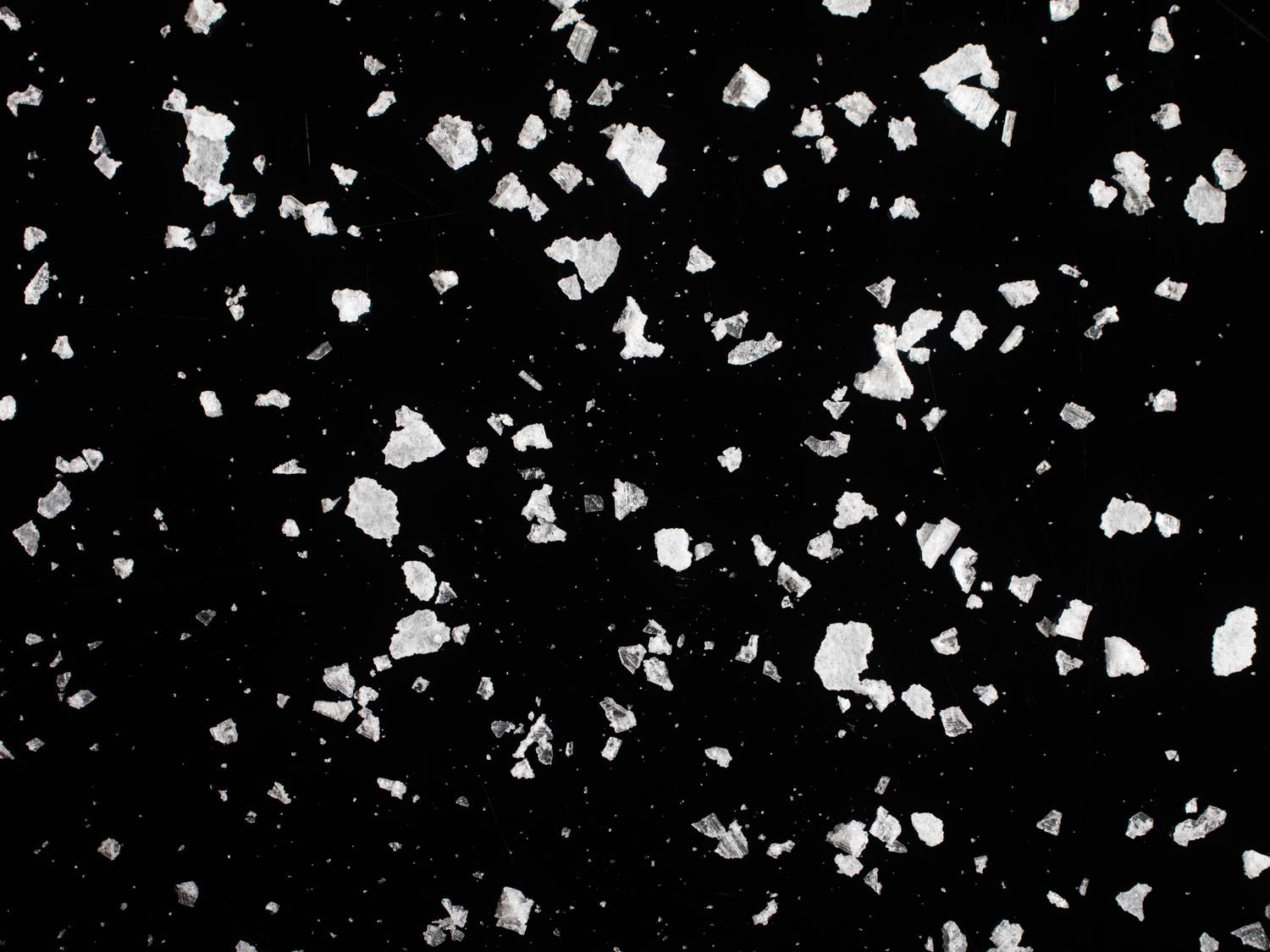 A closeup shot of salt crystals on a black background.