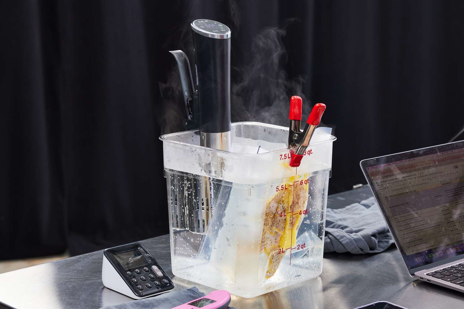 Instant Accu Slim Sous Vide Immersion Circulator in bucket of water with a packet of food