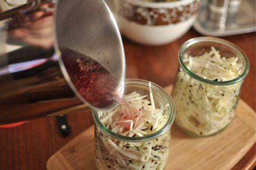 Boiling-hot brine is poured into the jars of shredded kohlrabi.