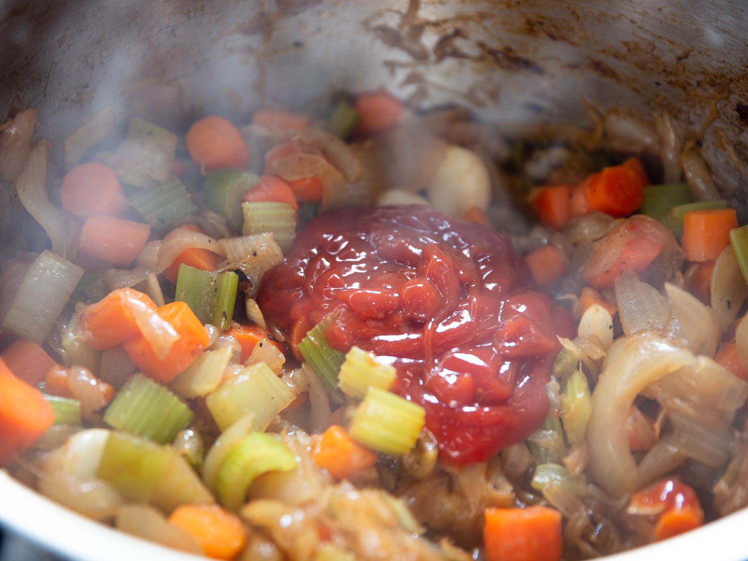 Ketchup is added to the softened aromatics in the pressure cooker.