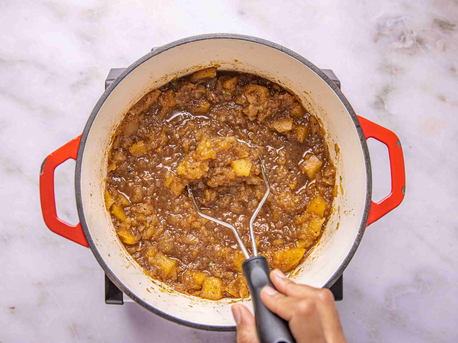Overhead view of mashing apples