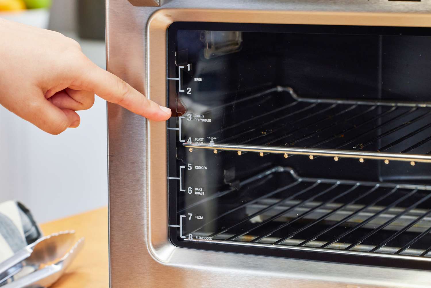 A hand pointing to the Breville the Smart Oven Air Fryer