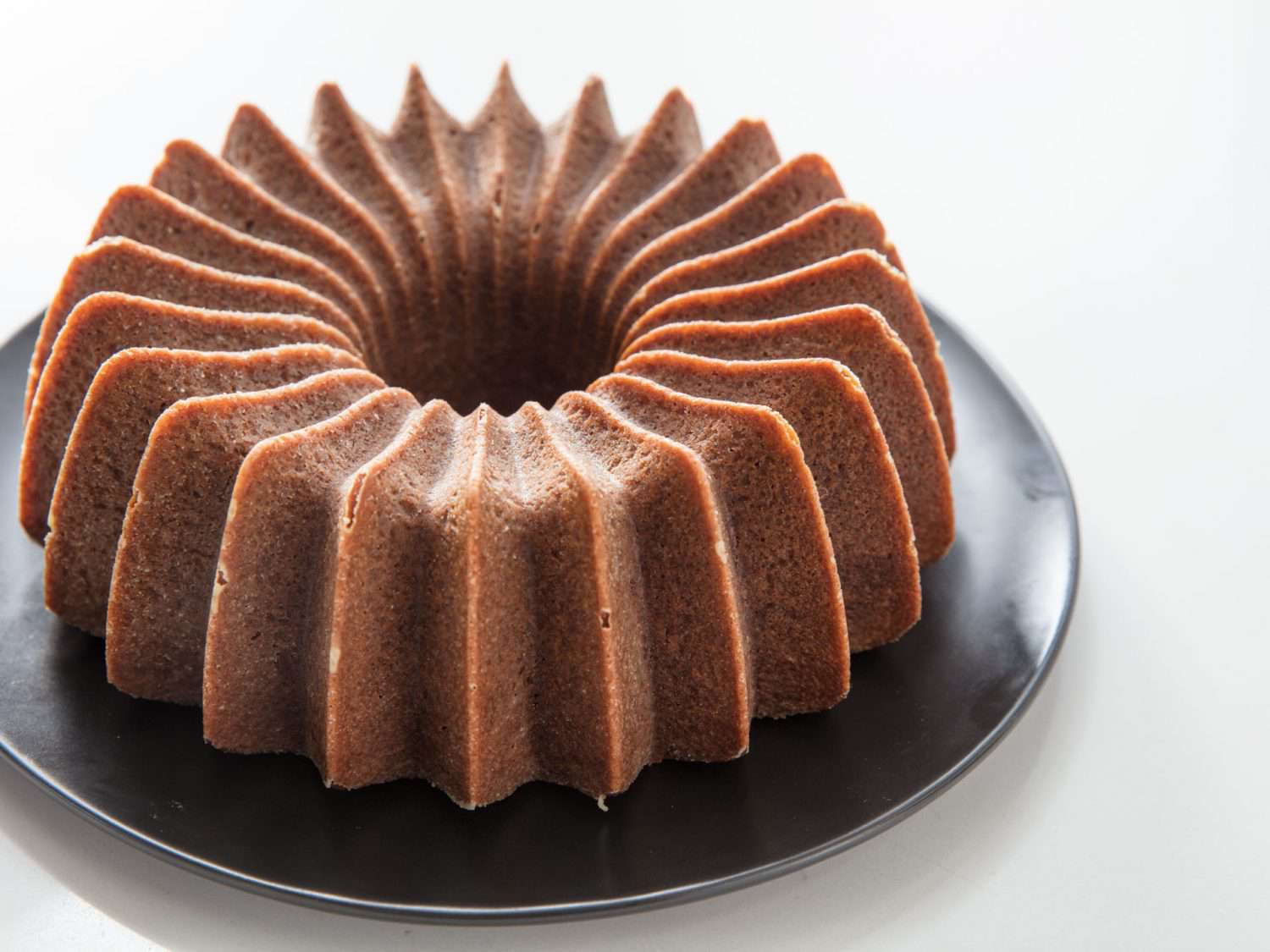 An ungarnished bundt cake baked in a Nordicware Brilliance Bundt Pan.