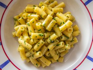 Pasta cacio e uova (Neapolitan pasta with eggs and cheese) on a white platter, garnished with fresh parsley. 