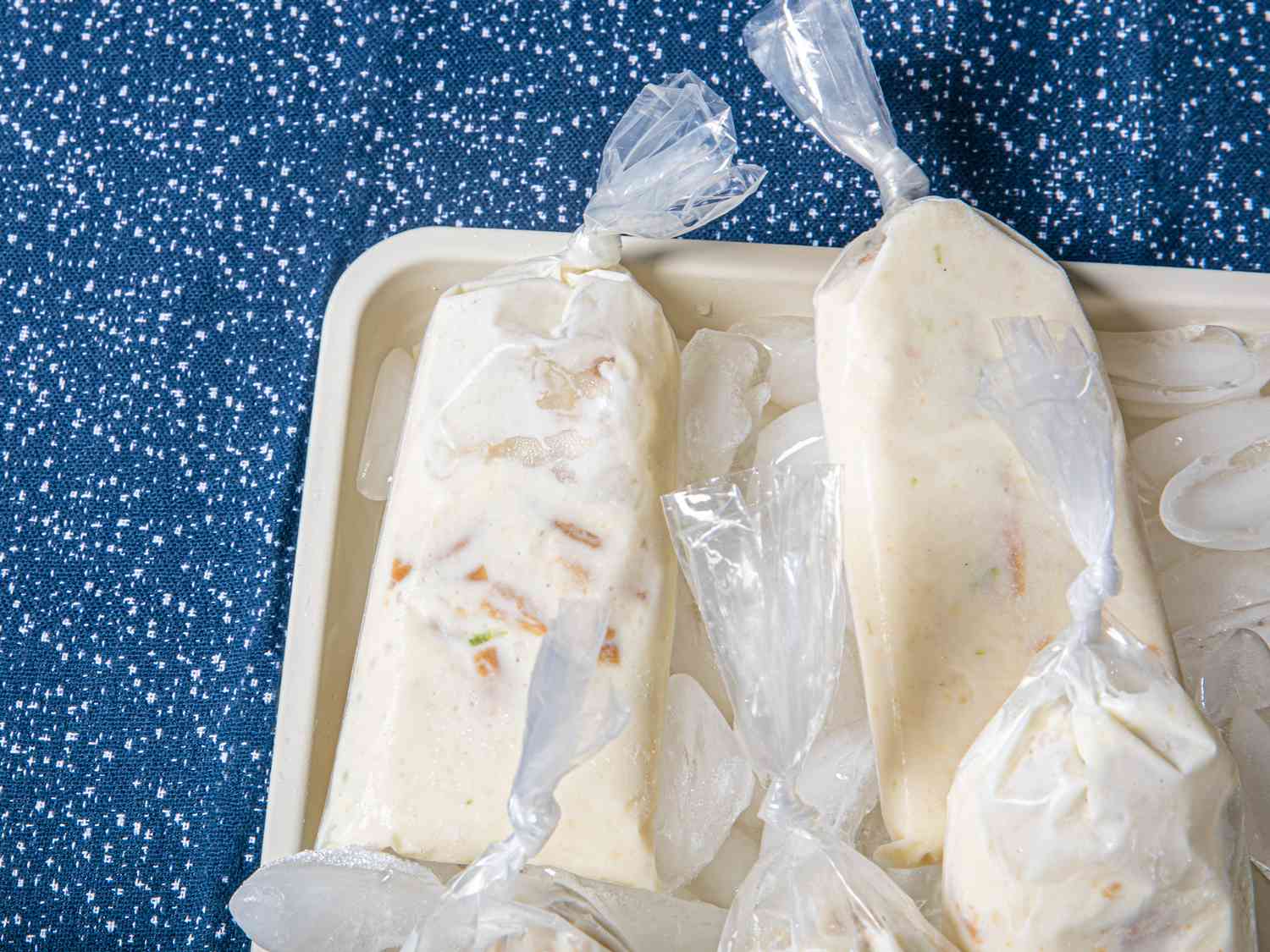 Frozen bolis on an ice tray on a spotted blue surface