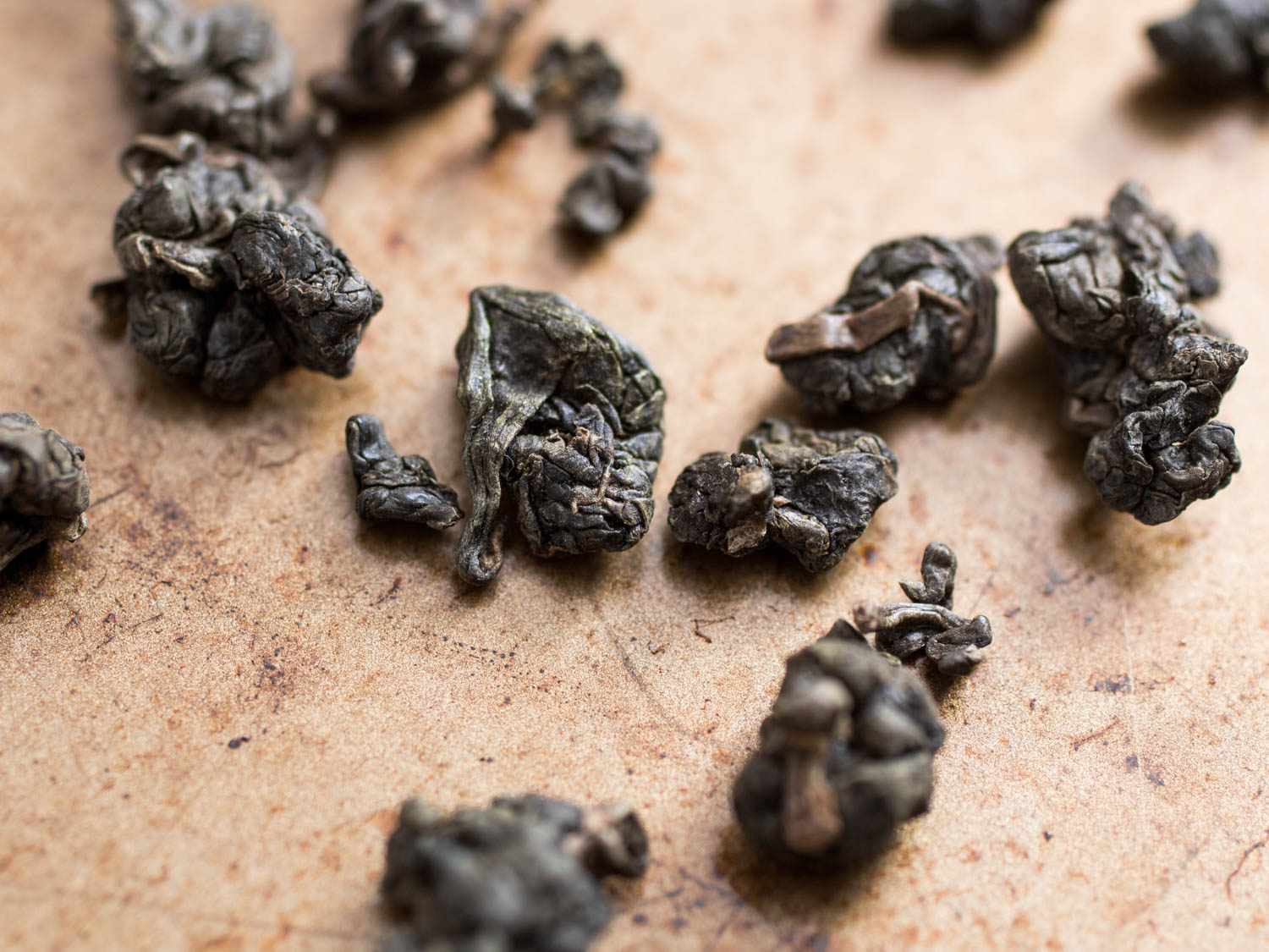 A closeup of dried dongding oolong tea leaves 