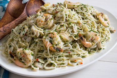 Closeup of Italian seafood-salad pasta salad with Vietnamese noodles, served on an oblong white platter.