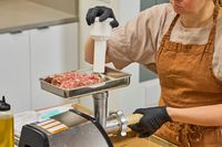 Person pushing meat in Weston #8 Electric Meat Grinder to stuff