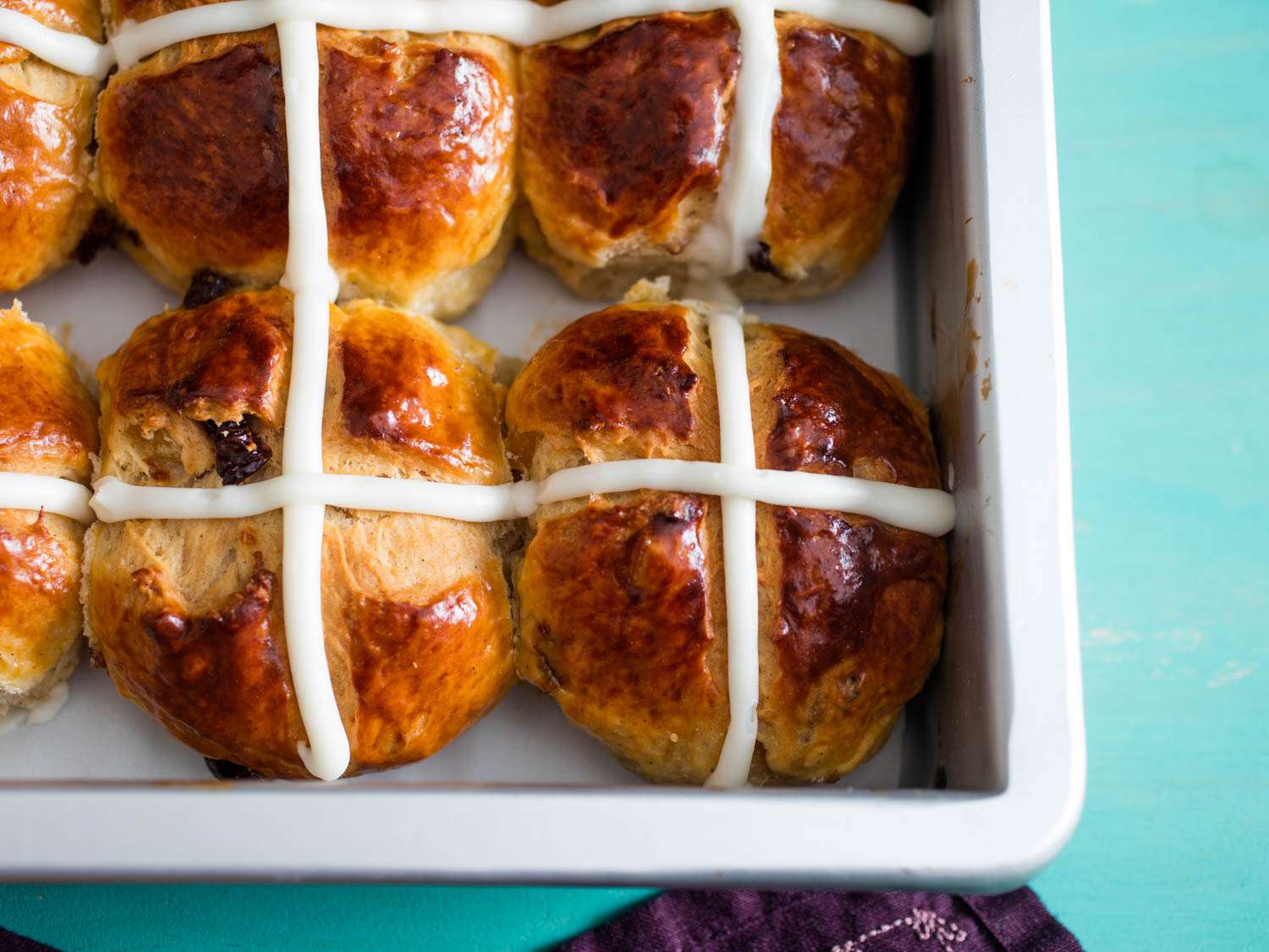 Close-up of iced hot cross buns in a brownie pan