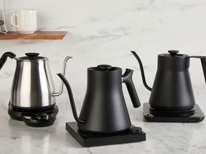 Three gooseneck kettles on a kitchen countertop.