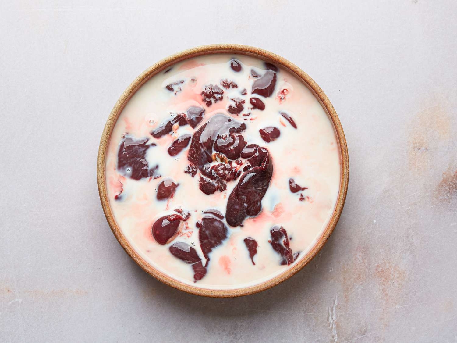 Overhead view of chicken livers in milk