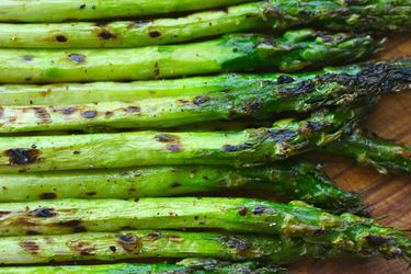 A pile of asparagus spears that have been slightly charred. 