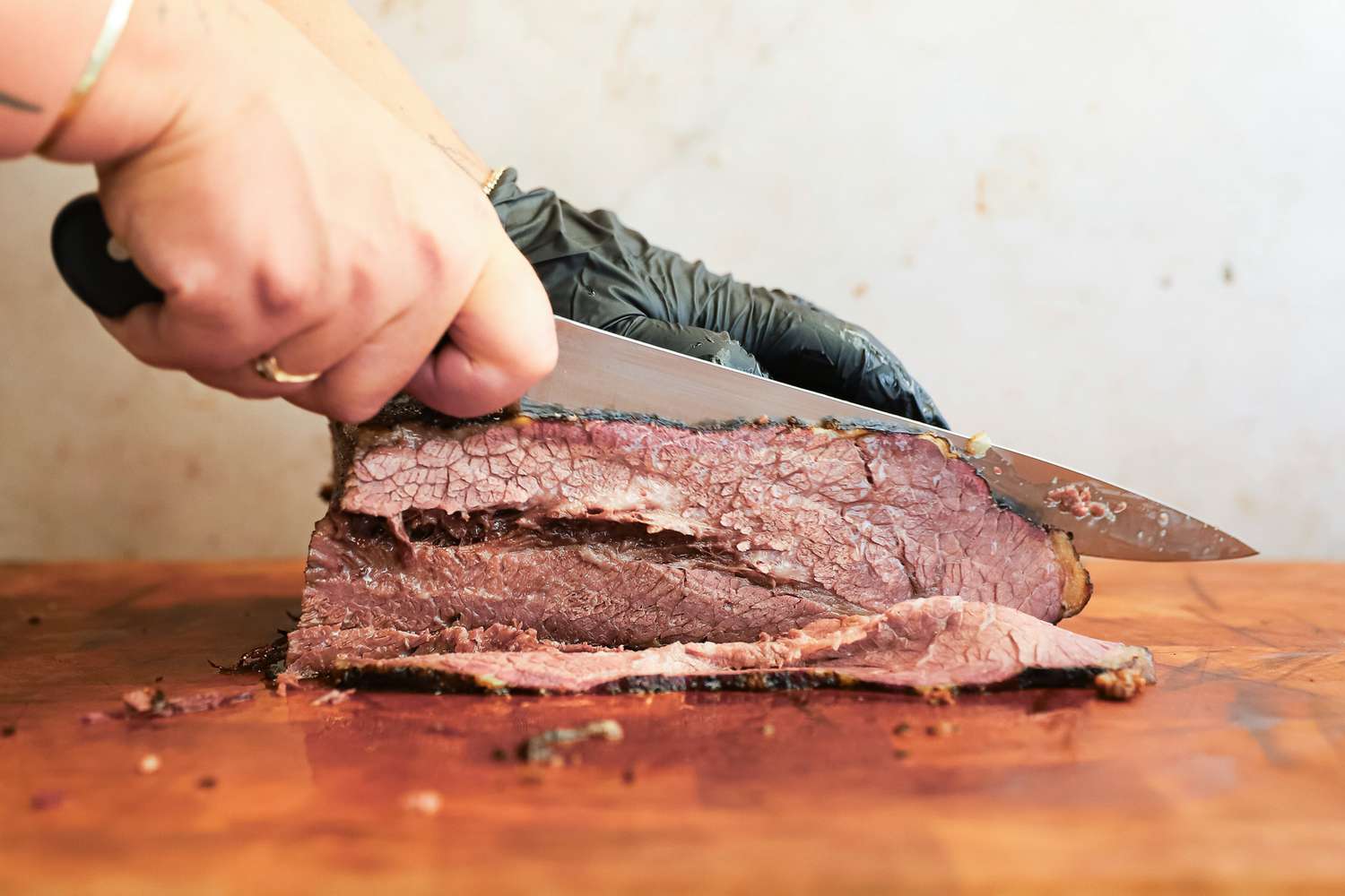 A person slicing meat using the Wusthof Classic Carving Knife