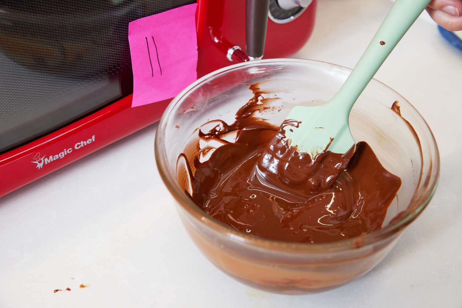 Chocolate is melted in a glass bowl in a microwave.
