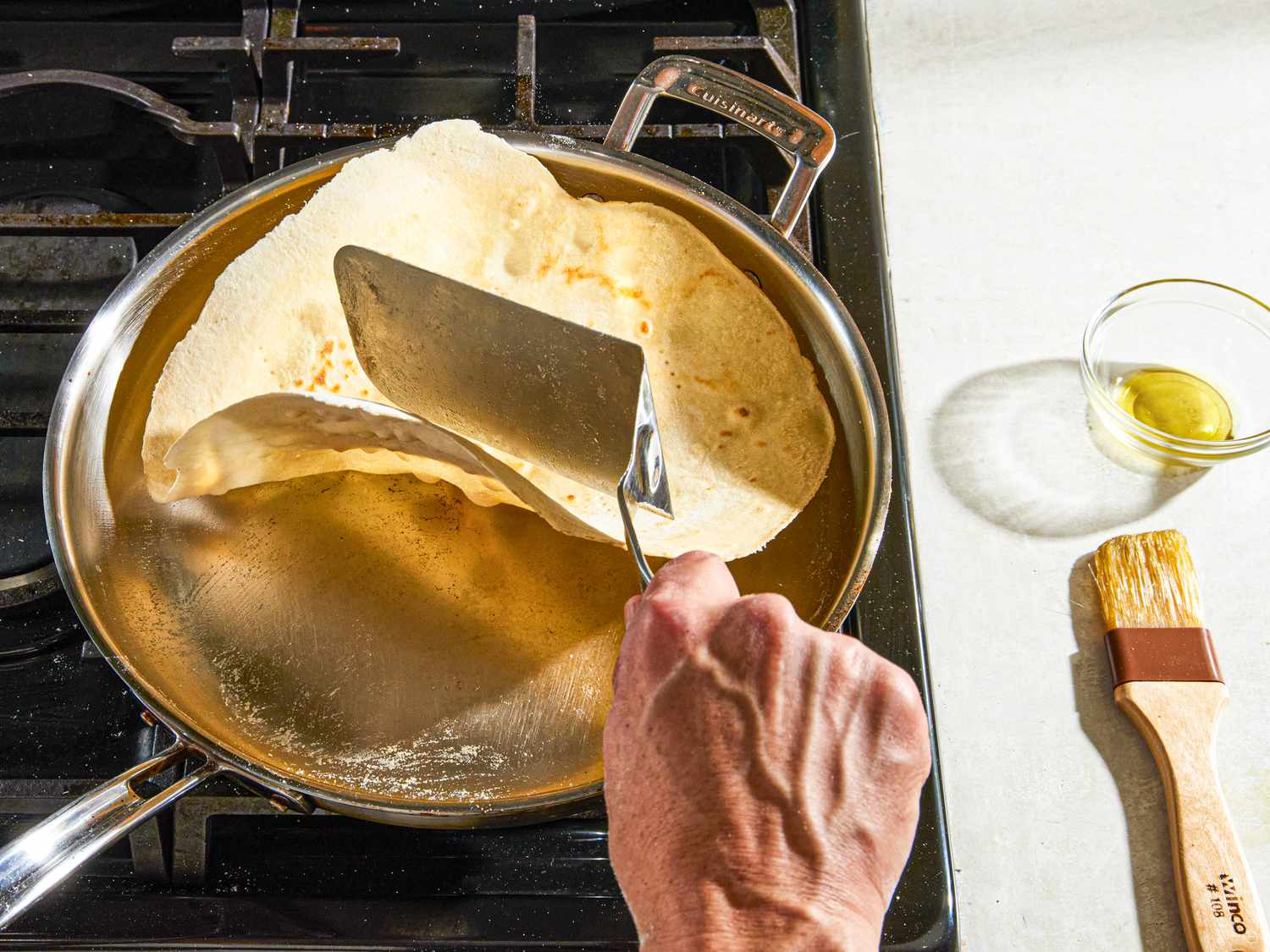 Side view of flipping piadina dough