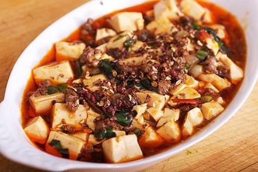 Mapo Tofu with ramps, served in a shallow, white, ovoid serving bowl.