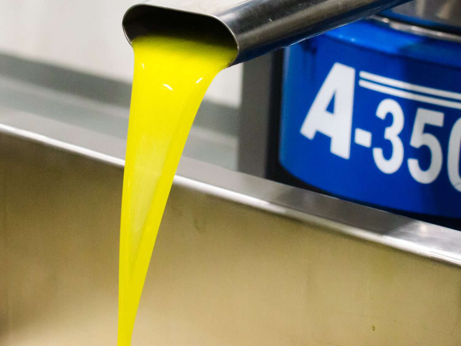 Olive oil pouring from a spout, freshly pressed.