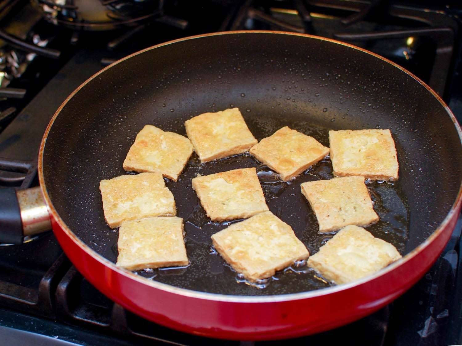 pan-frying slices of coated tofu in skillet