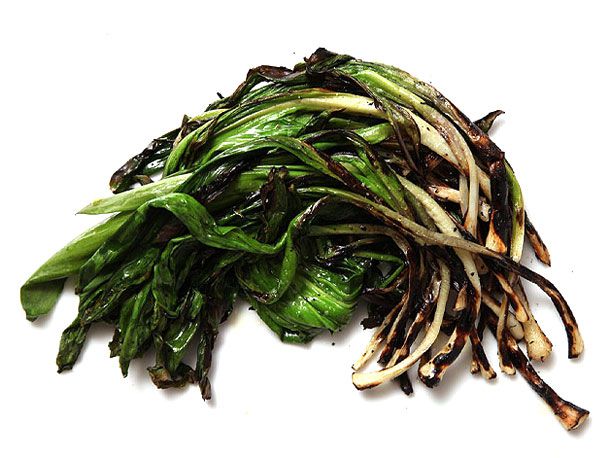 A mess of grilled ramps, strewn on a white background.