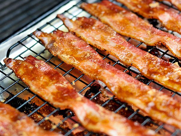 Crispy bacon slices resting on a wire rack. 