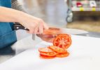 Hands slicing a tomato with a Misono UX10 8.2-Inch Gyutou