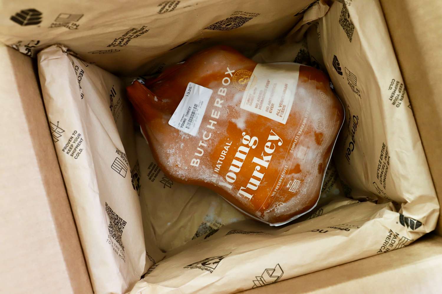 A frozen young turkey from ButcherBox inside a cardboard box with insulation material