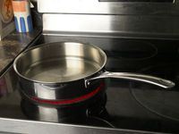 le creuset saute pan on a glass stove top