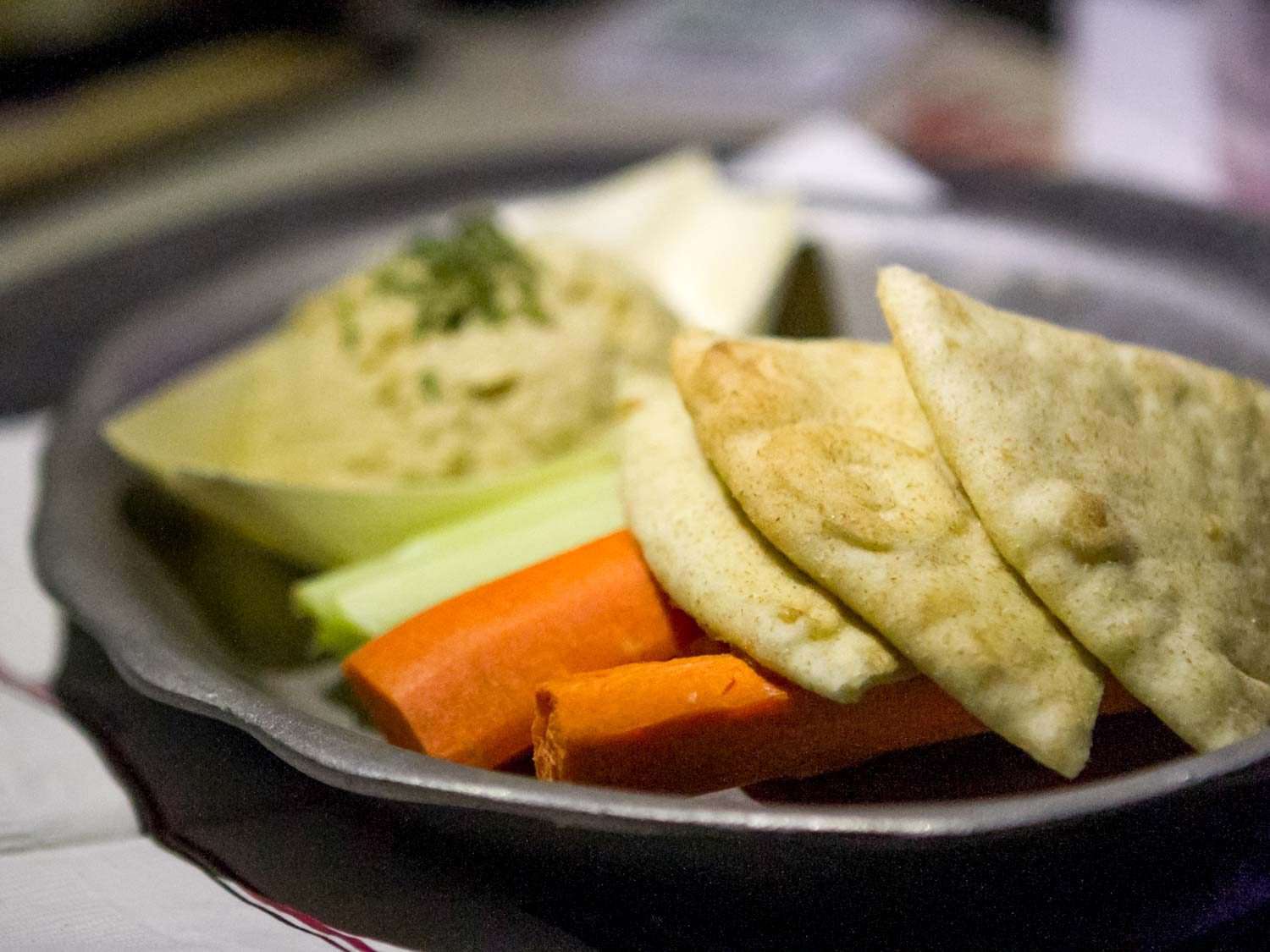 Close-up of an appetizer plate at Medieval Times: pita wedges, carrot sticks, celery sticks, and hummus