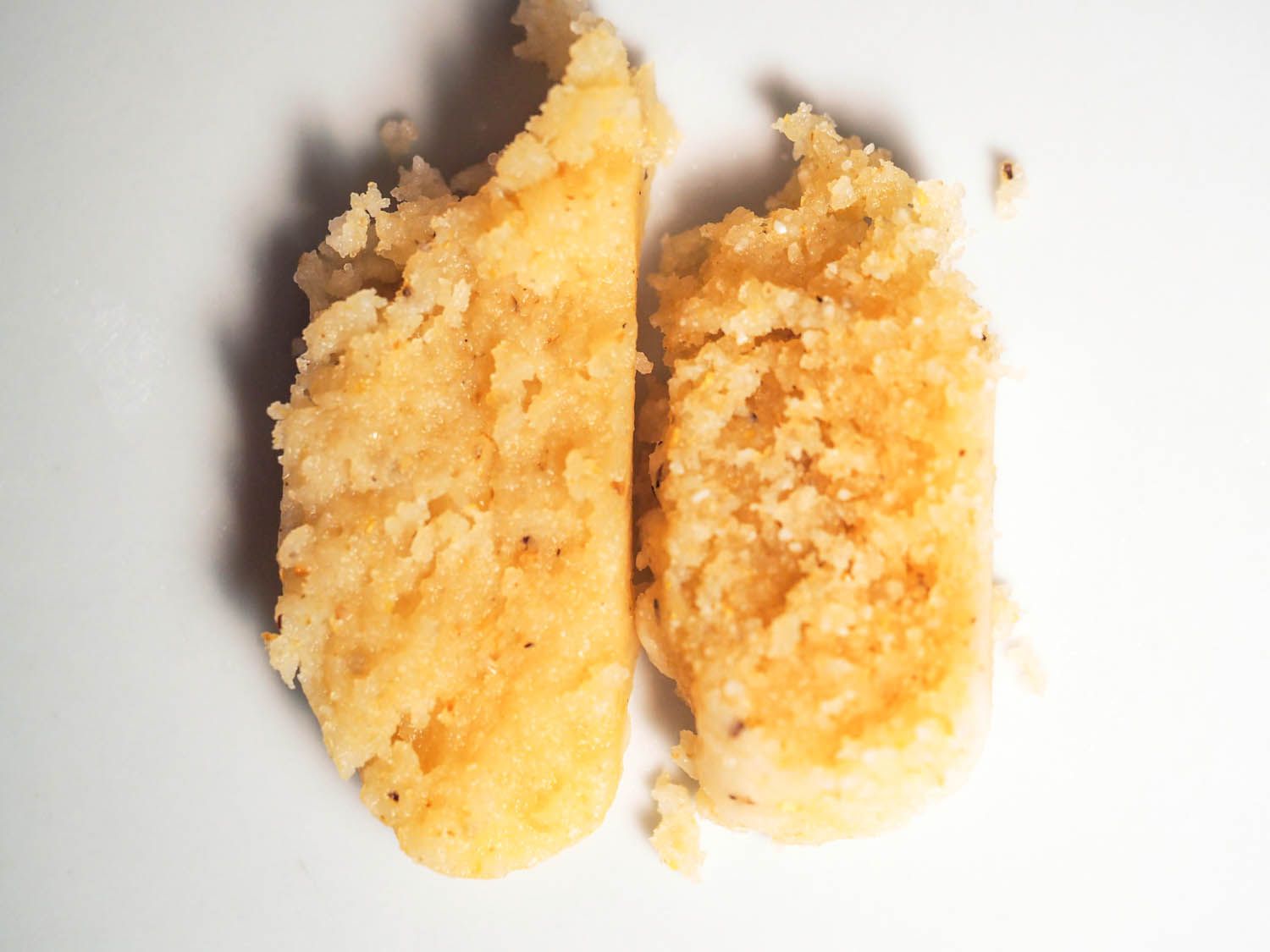 Two slices of tamale. The one on the left looks moister and less crumbly than the one on the right.