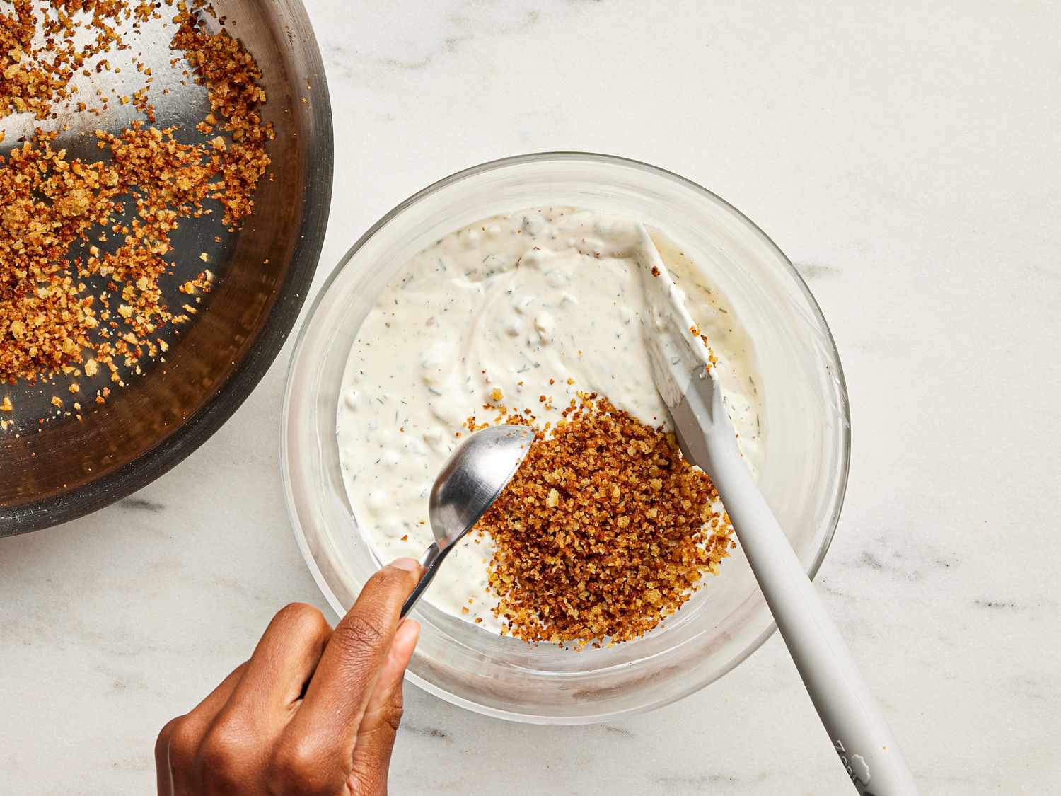 Bowl of dip with pickled panko being spooned onto it. 