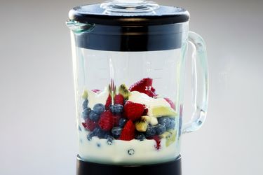Blender jar containing fruits and yogurt