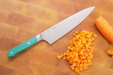 the misen chef knife on a wooden cutting board with a diced carrot