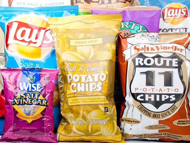An assortment of bags of salt and vinegar potato chips.