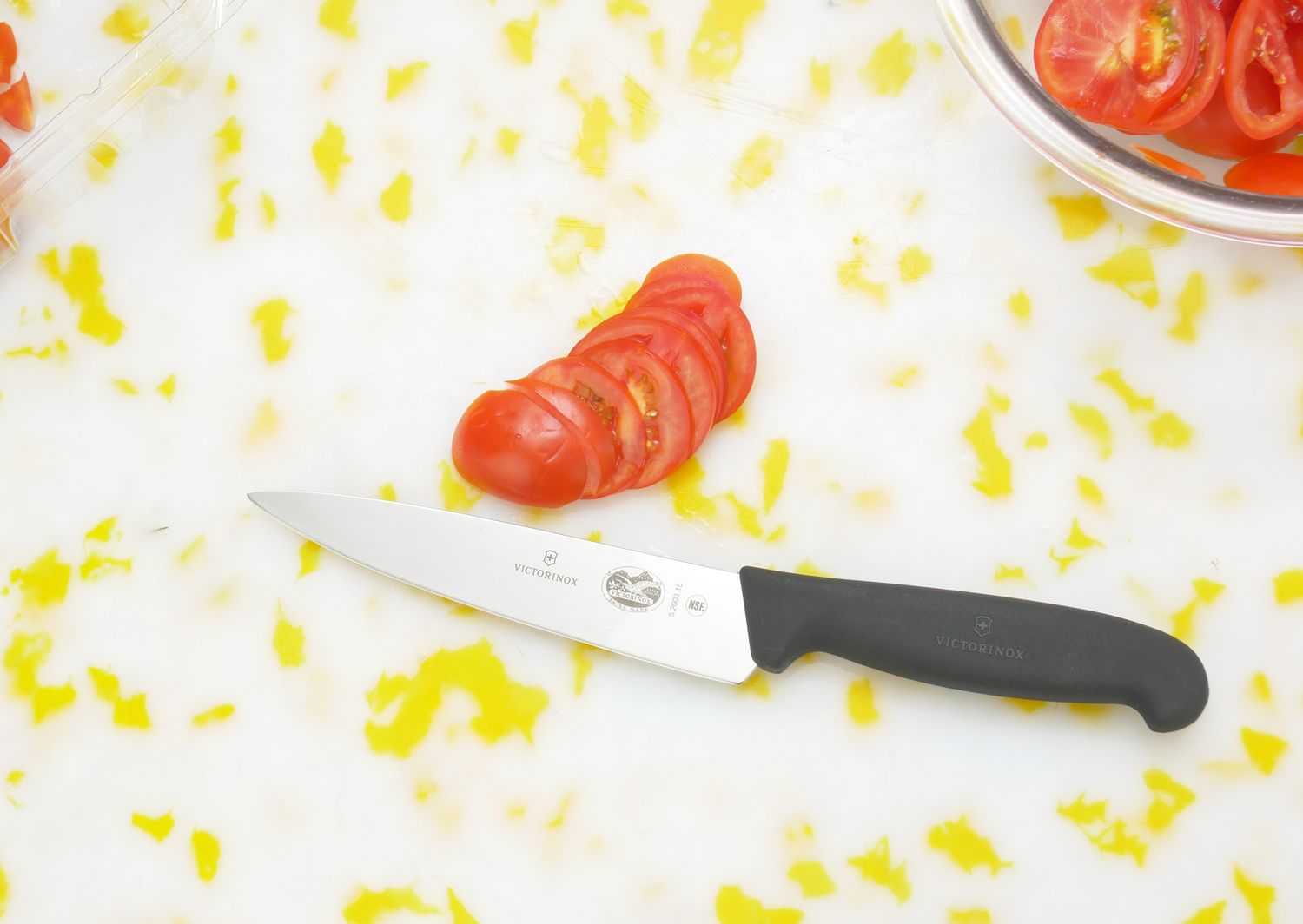 a knife next to a sliced tomato