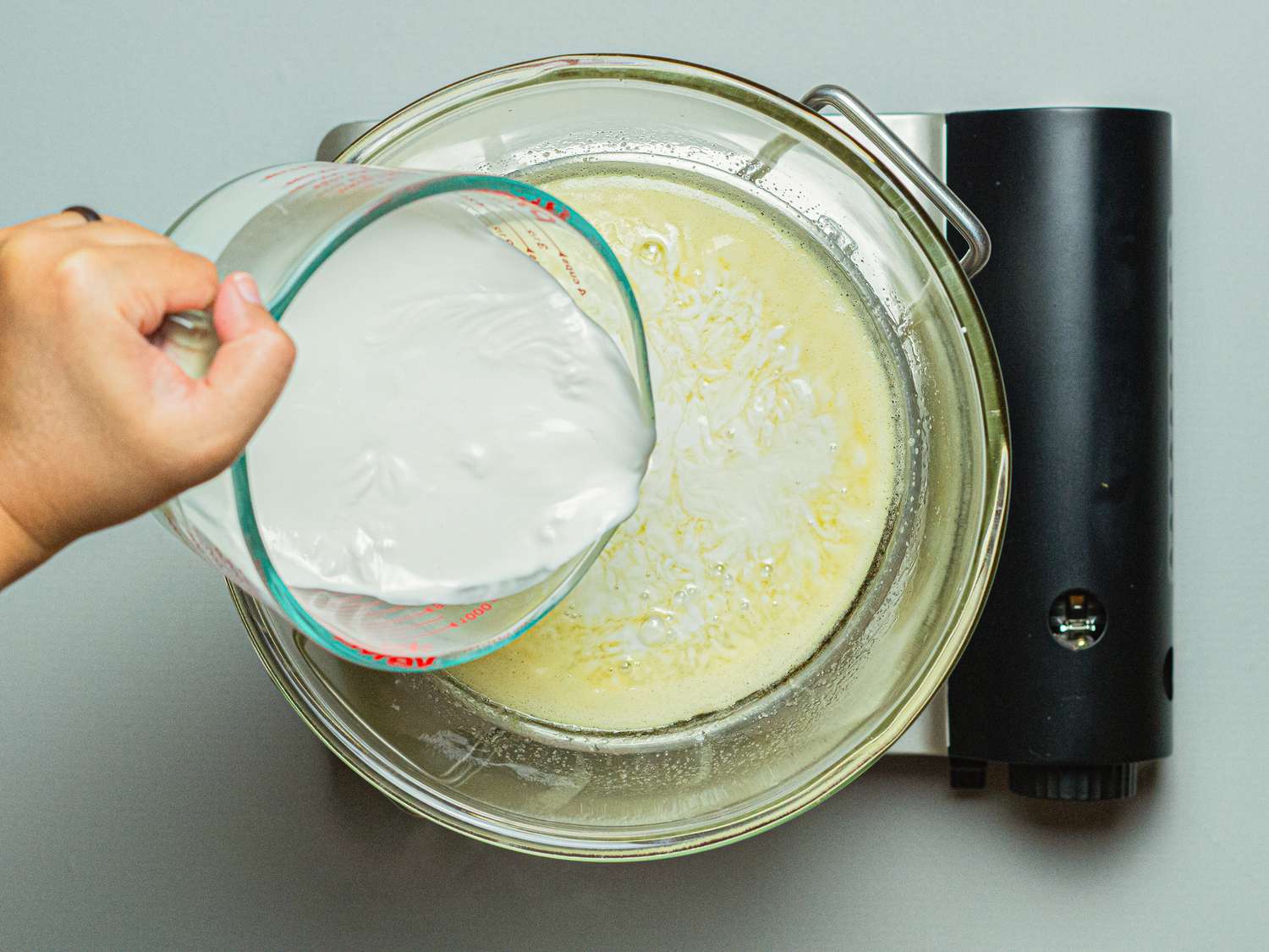 Overhead view of adding coconut milk